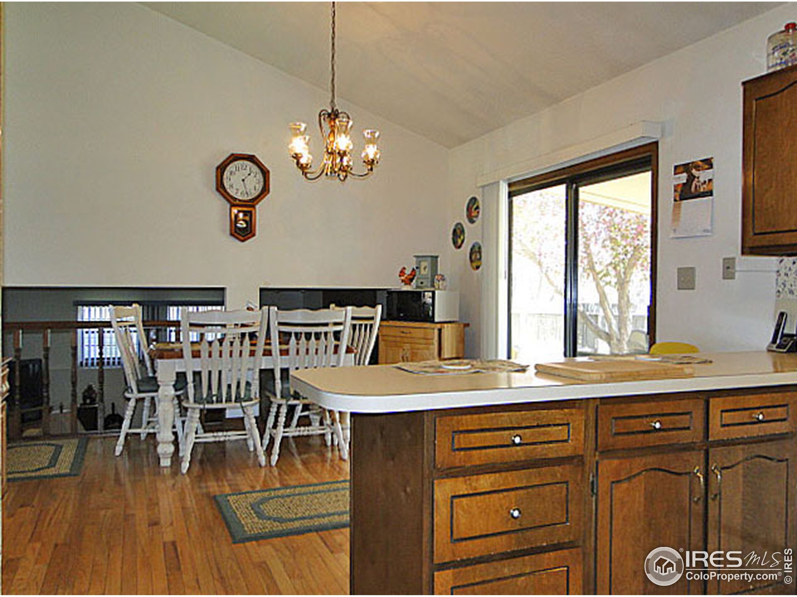 3334 34th Street Greeley, CO 80634 - Photo 9 of 25 a dining hall with granite countertop a stove a sink dishwasher a dining table and chairs with wooden floor