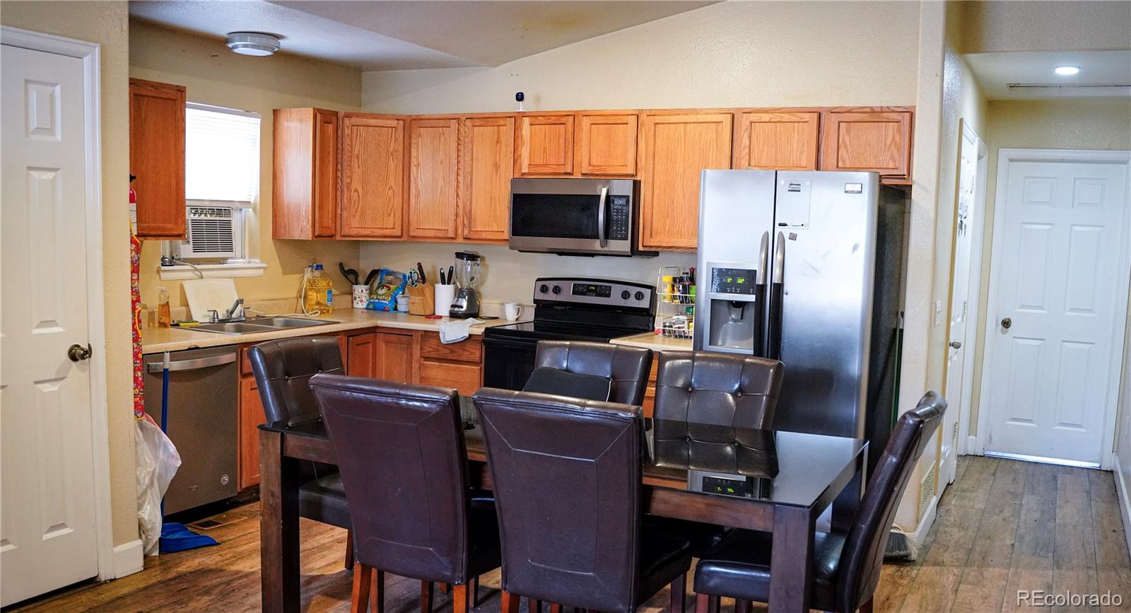 4582 West Alameda Avenue Denver, CO 80219 - Photo 3 of 17 a kitchen with stainless steel appliances a refrigerator stove microwave and cabinets