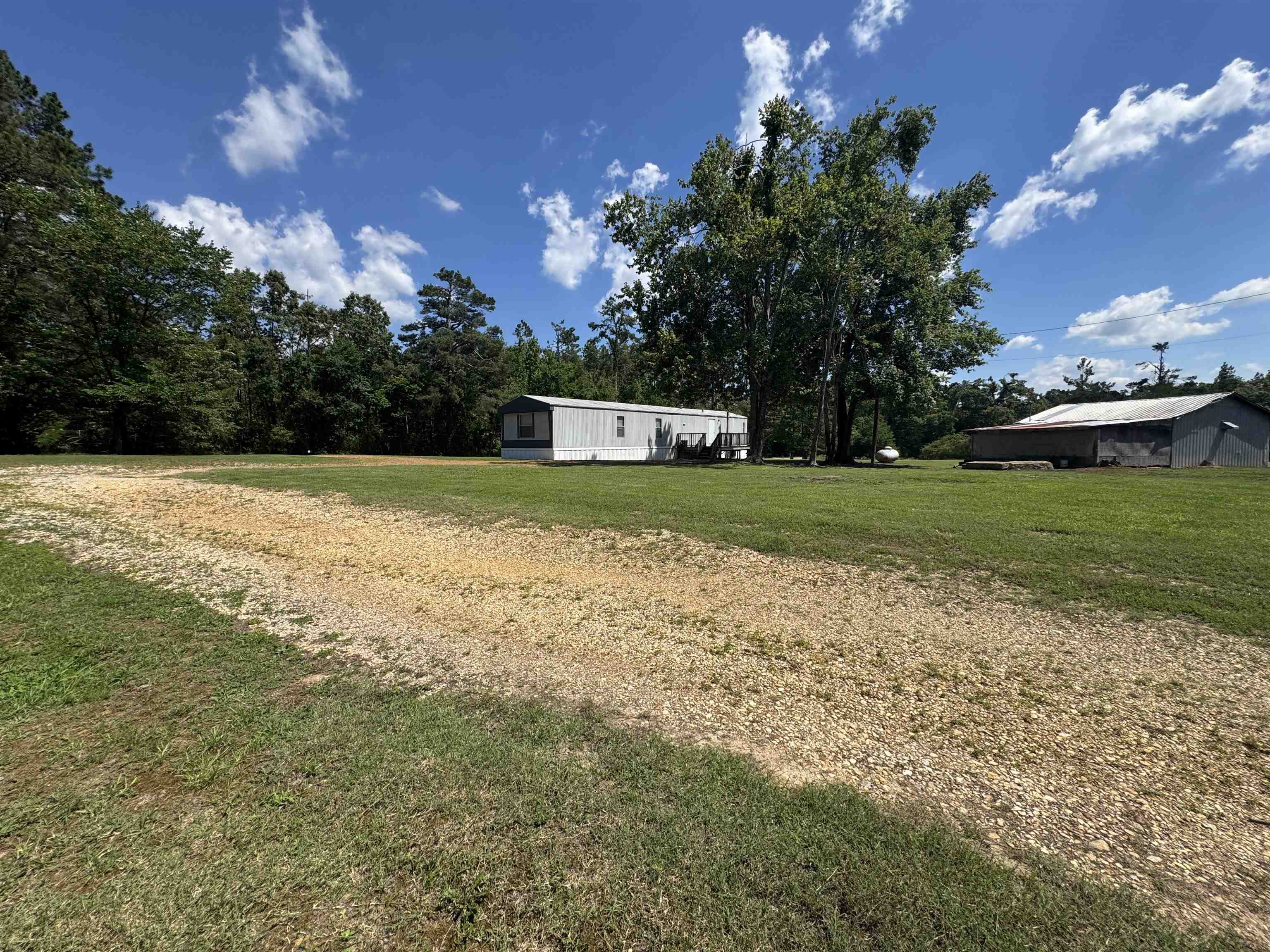 2511 Watkins Road Michie, TN 38357 - Photo 31 of 40 Spacious property featuring a mobile home, extensive lawn, and a large outbuilding