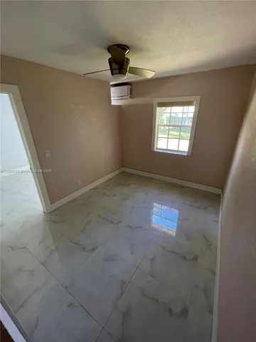 an empty room with windows and ceiling fan