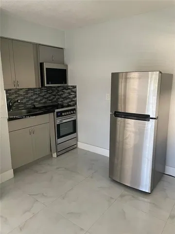 a kitchen with a refrigerator and microwave