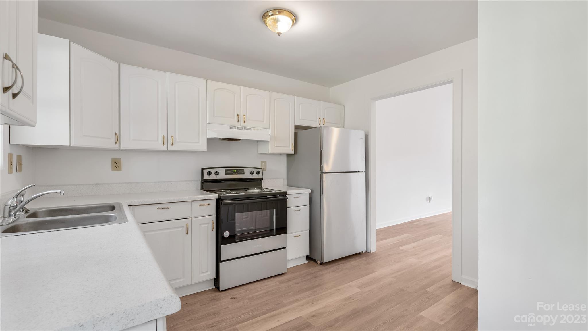 3733 Oakwood Road, Unit A Charlotte, NC 28269 - Photo 5 of 15 a kitchen with cabinets stainless steel appliances and a sink