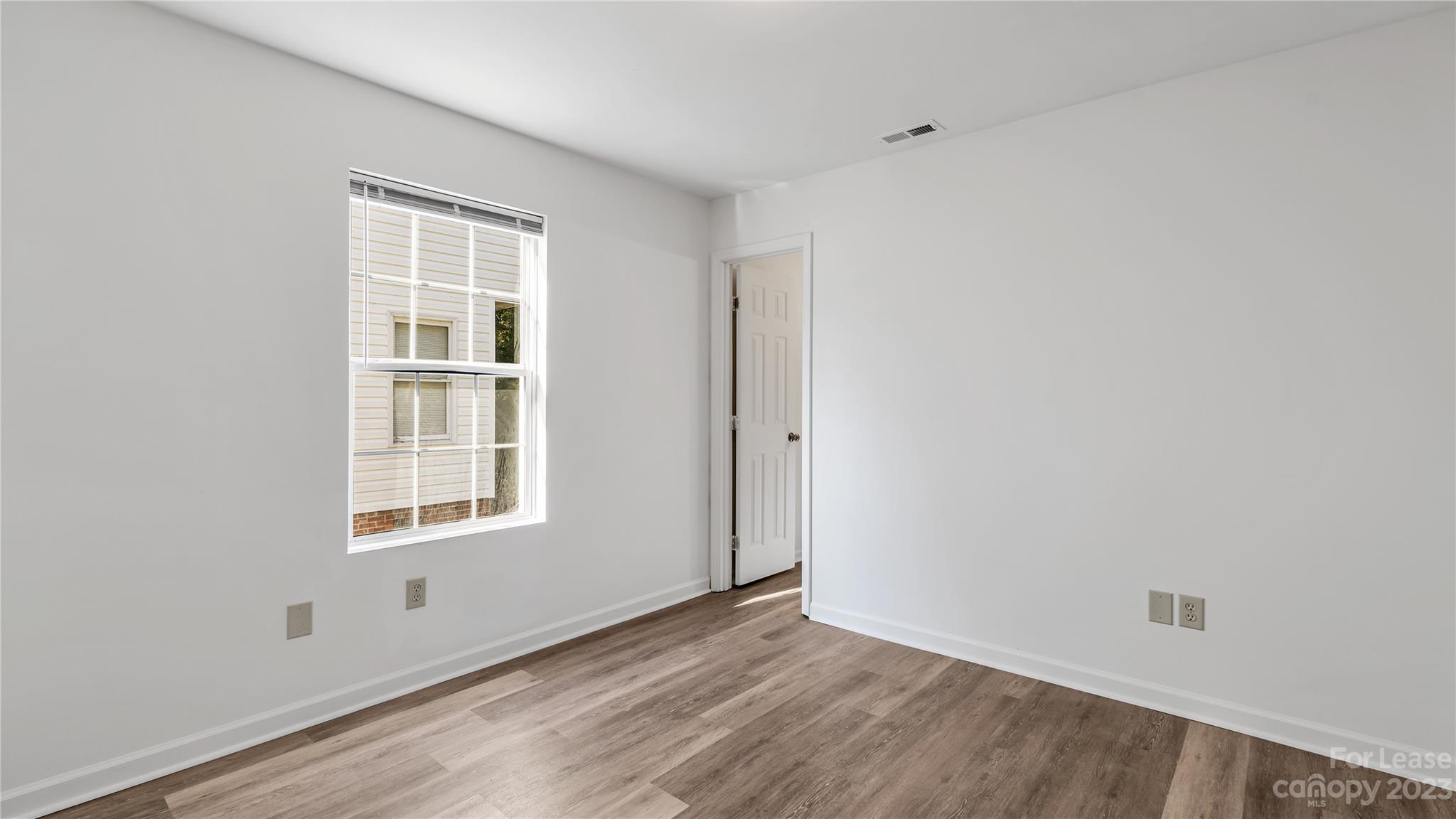 3733 Oakwood Road, Unit A Charlotte, NC 28269 - Photo 10 of 15 an empty room with wooden floor and windows
