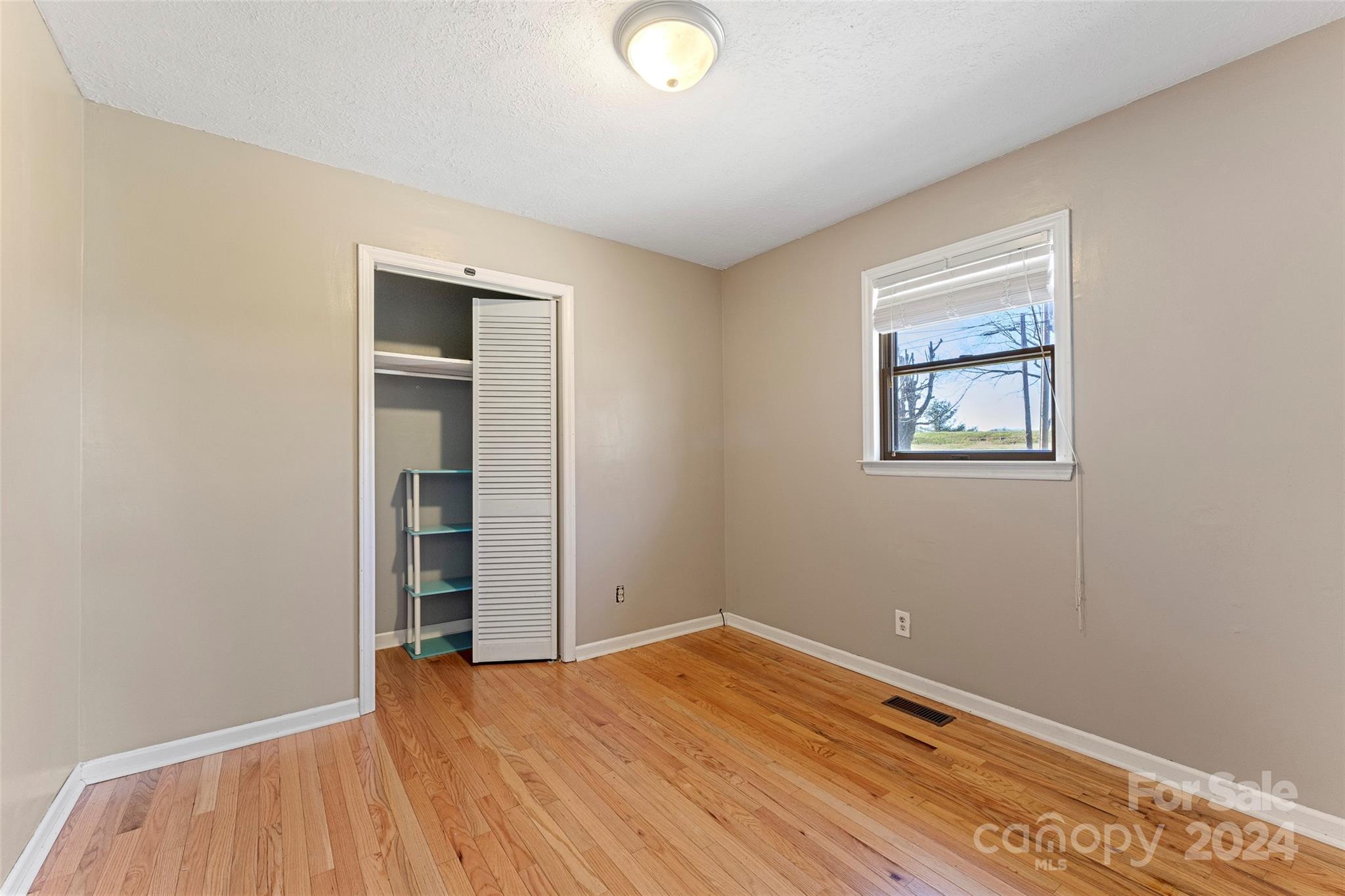 616 Oak Grove Road Flat Rock, NC 28731 - Photo 17 of 36 a view of empty room with wooden floor and fan