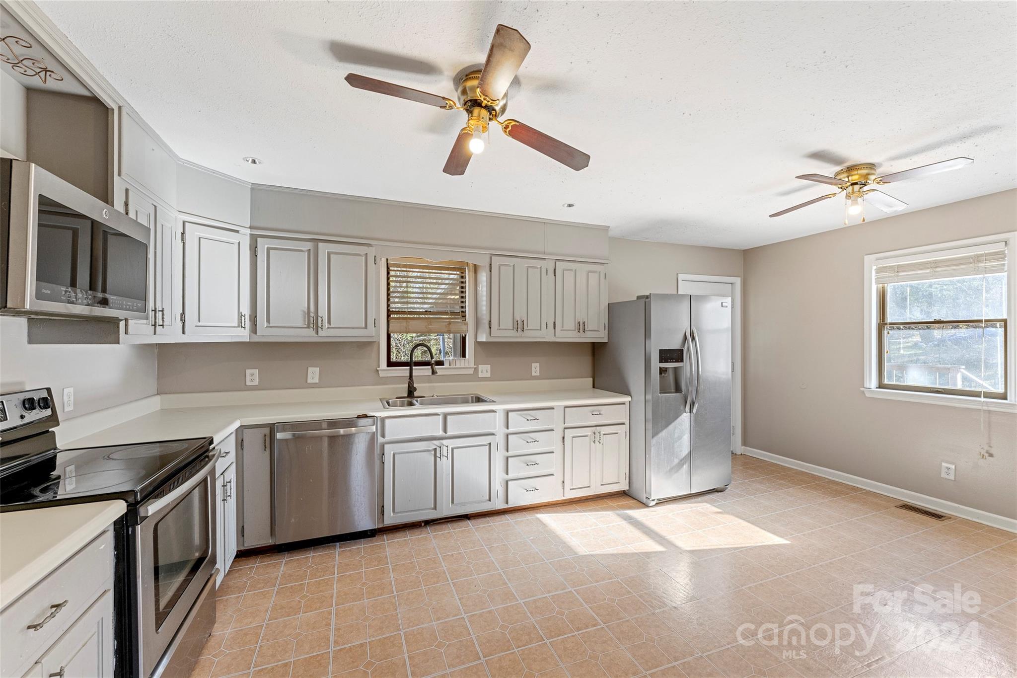 616 Oak Grove Road Flat Rock, NC 28731 - Photo 6 of 36 a kitchen with stainless steel appliances granite countertop a sink a stove a refrigerator a microwave oven with cabinets and appliances