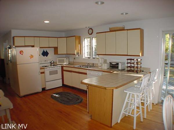 27 Vickers Street Edgartown, MA 02539 - Photo 4 of 5 a kitchen with a sink a stove a refrigerator and cabinets