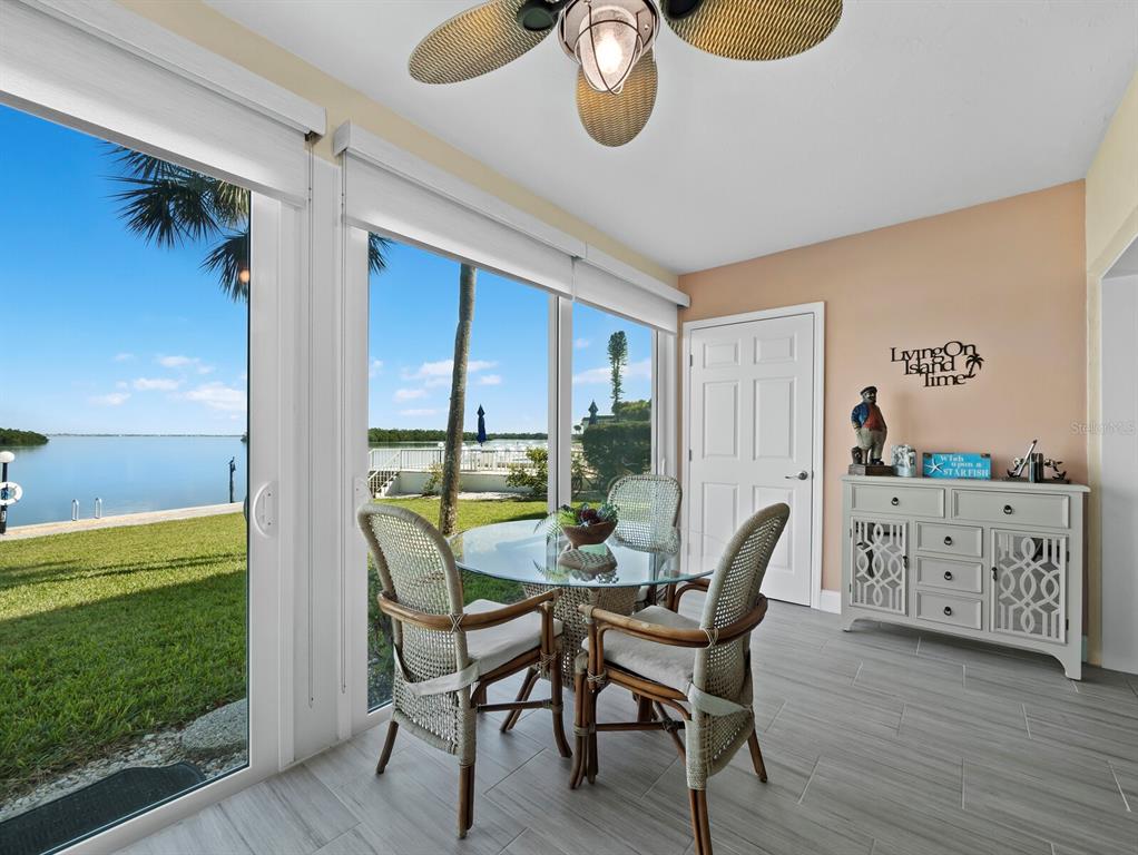 4430 Exeter Drive, Unit 106 Longboat Key, FL 34228 - Photo 11 of 57 a dining room with furniture and a floor to ceiling window