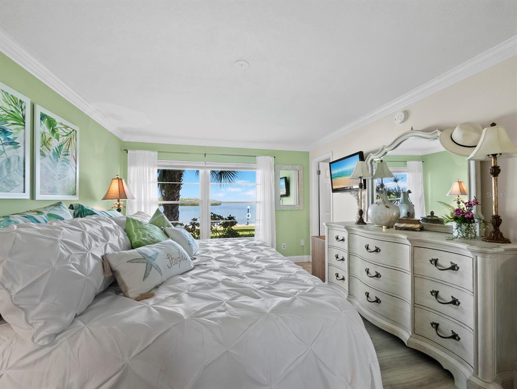 4430 Exeter Drive, Unit 106 Longboat Key, FL 34228 - Photo 21 of 57 a large bedroom with a bed and large windows