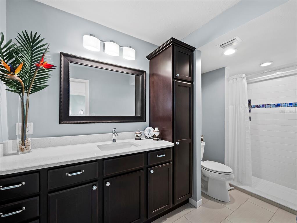 4430 Exeter Drive, Unit 106 Longboat Key, FL 34228 - Photo 23 of 57 a bathroom with a double vanity sink toilet and a mirror
