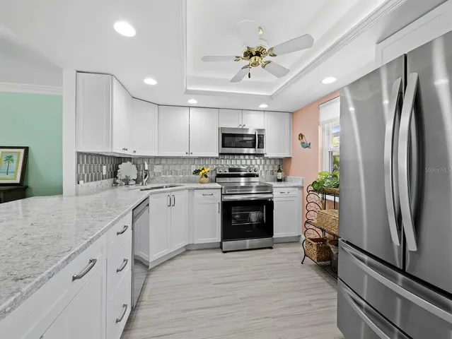 a kitchen with granite countertop kitchen island stainless steel appliances a table and chairs in it