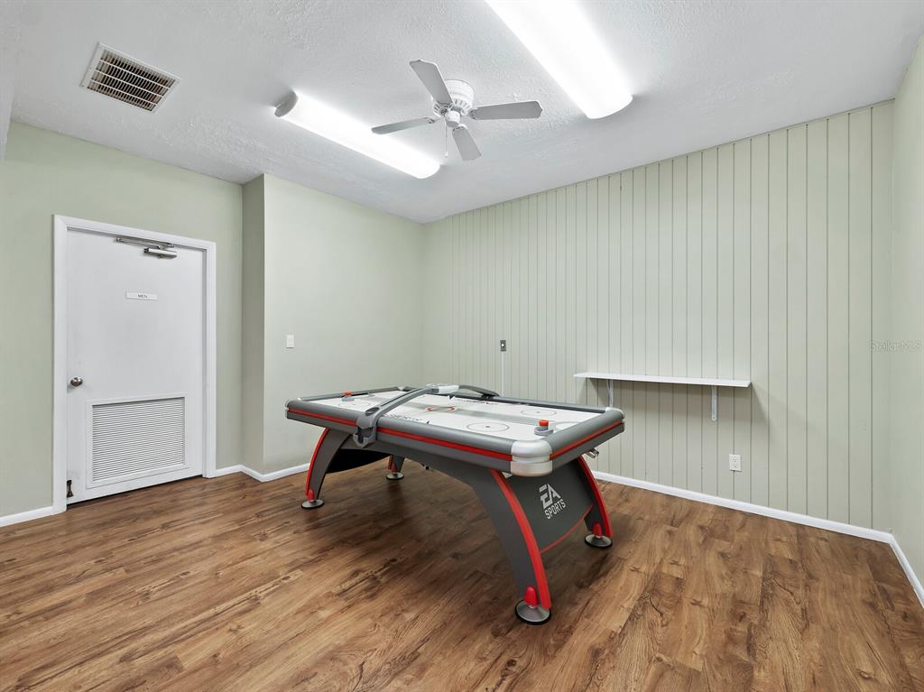 4430 Exeter Drive, Unit 106 Longboat Key, FL 34228 - Photo 37 of 57 a room with wooden floor and a ceiling fan