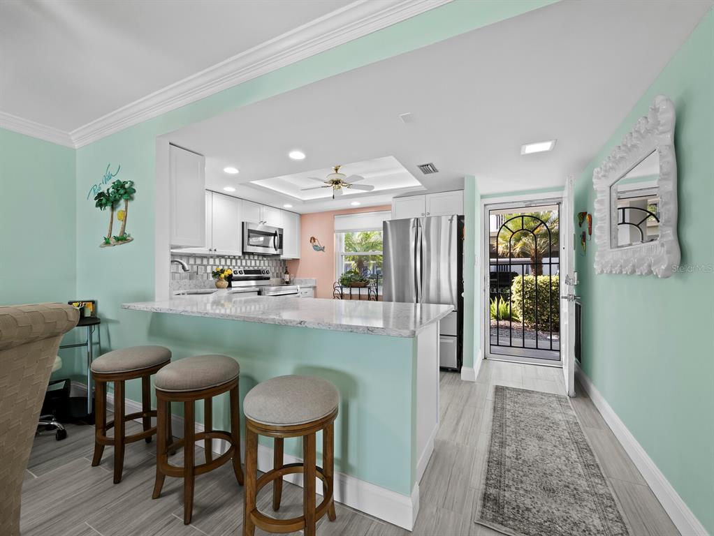 4430 Exeter Drive, Unit 106 Longboat Key, FL 34228 - Photo 4 of 57 a kitchen with granite countertop kitchen island stainless steel appliances a table and chairs in it