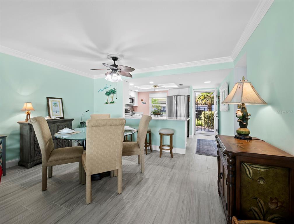 4430 Exeter Drive, Unit 106 Longboat Key, FL 34228 - Photo 6 of 57 a view of a dining room with furniture and wooden floor