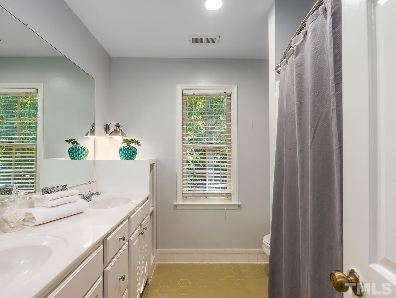 4208 Webster Court Raleigh, NC 27609 - Photo 18 of 28 a bathroom with a granite countertop sink and a mirror