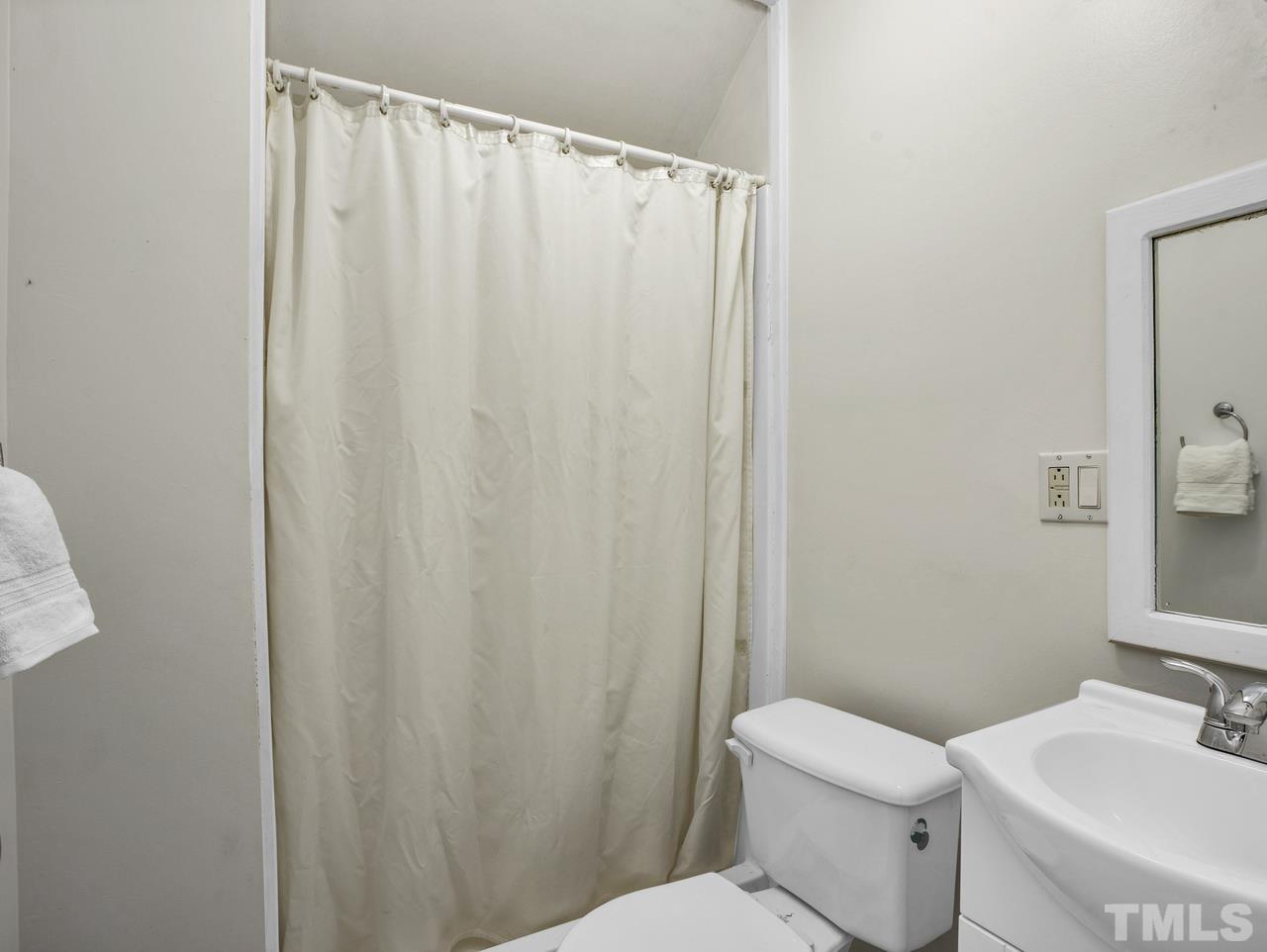 4208 Webster Court Raleigh, NC 27609 - Photo 21 of 28 a white toilet sitting next to a bathroom sink