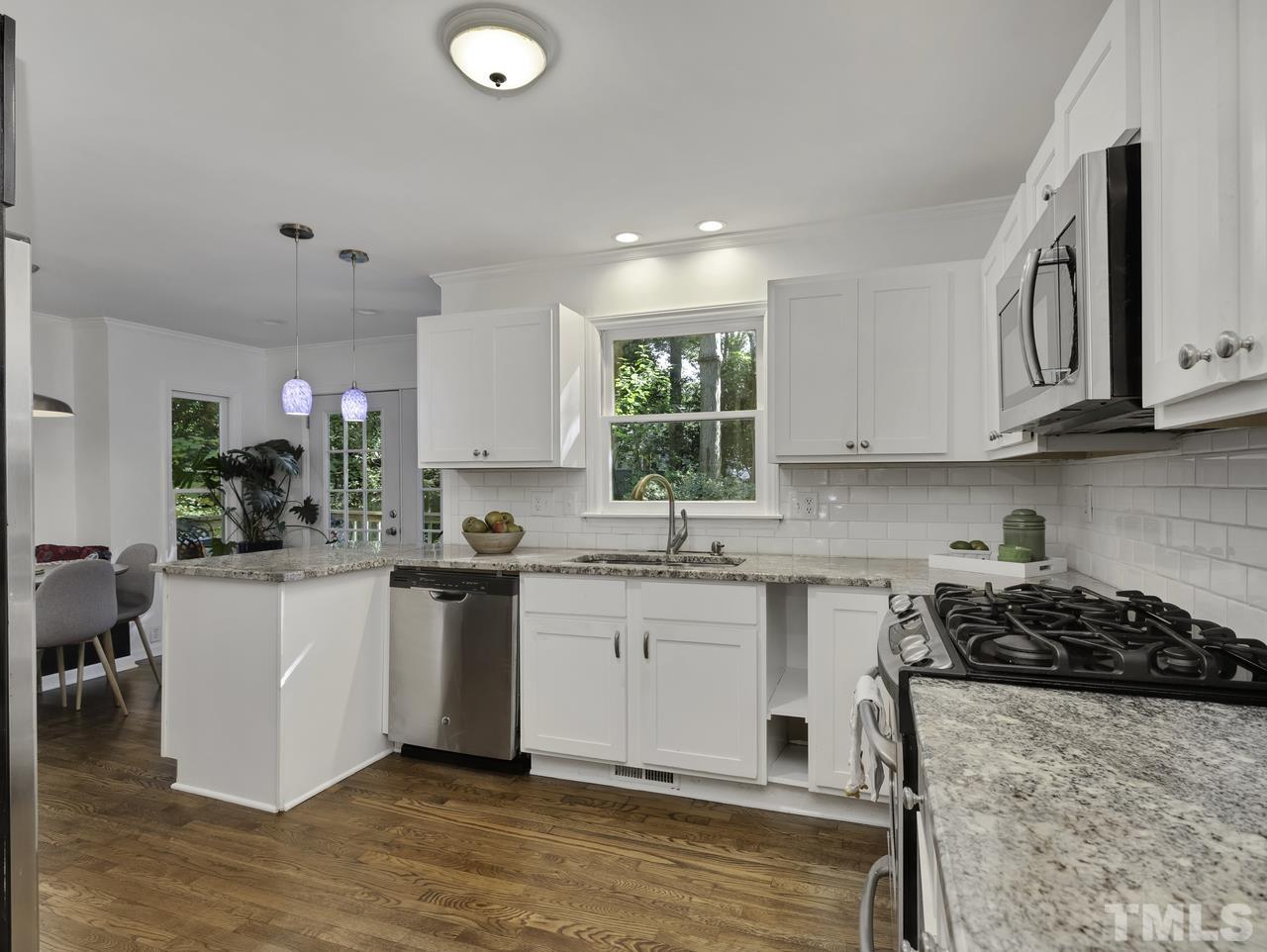 4208 Webster Court Raleigh, NC 27609 - Photo 6 of 28 a kitchen with a sink white cabinets and wooden floor