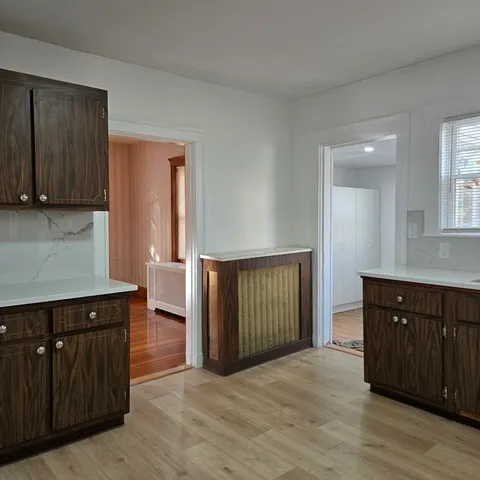 a view of a kitchen with wooden floor and cabinets