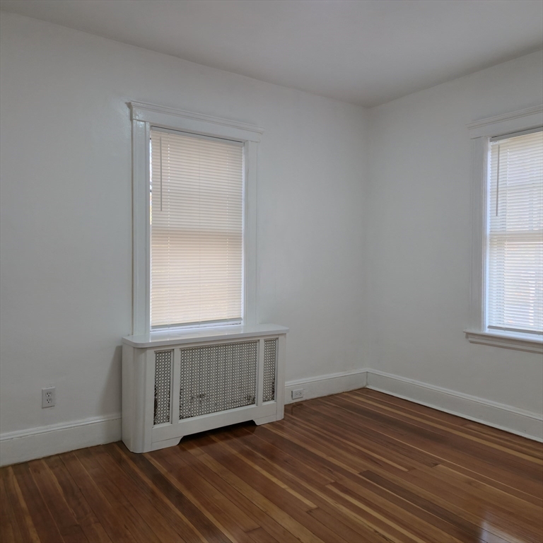 22 Hope Avenue, Unit 22 Milton, MA 02186 - Photo 15 of 36 an empty room with wooden floor and windows