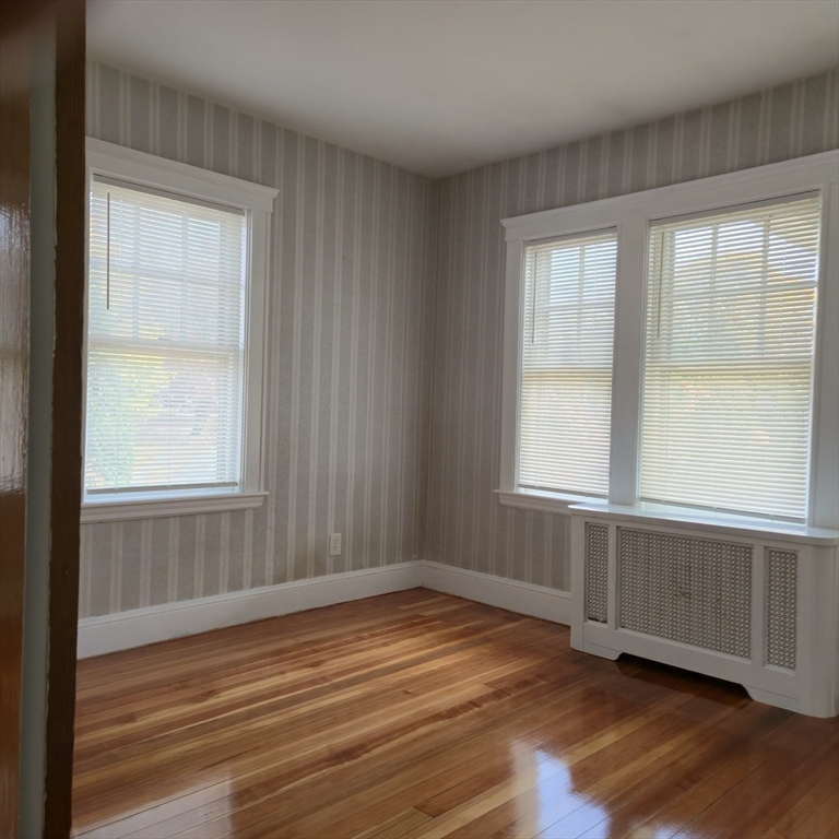 22 Hope Avenue, Unit 22 Milton, MA 02186 - Photo 19 of 36 an empty room with wooden floor and windows