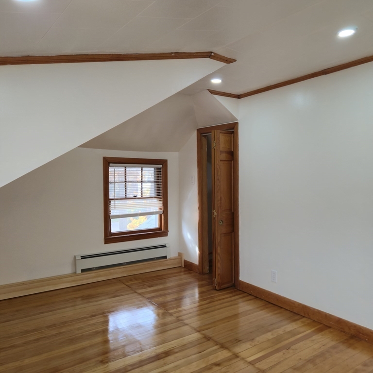 22 Hope Avenue, Unit 22 Milton, MA 02186 - Photo 26 of 36 an empty room with wooden floor and windows with curtains