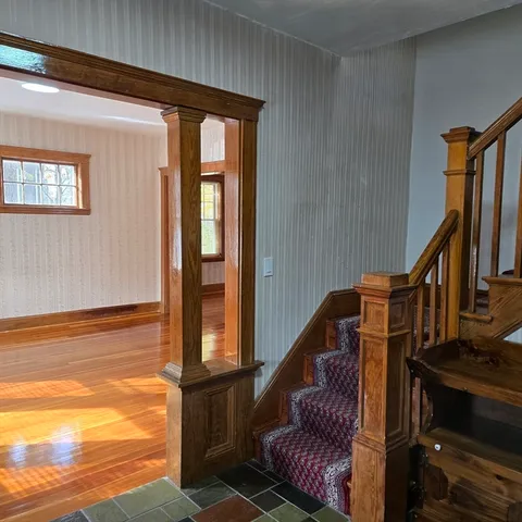 a view of entryway and hall with wooden floor