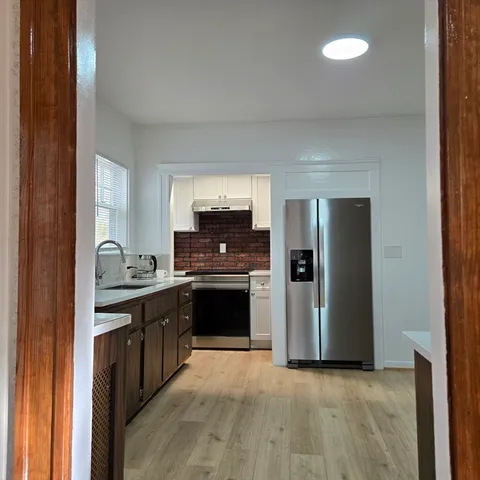 a kitchen with stainless steel appliances granite countertop a stove a sink and a refrigerator