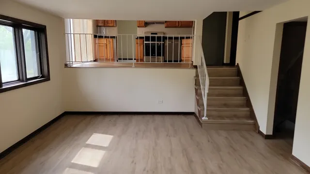 an entryway with wooden floor and stairs