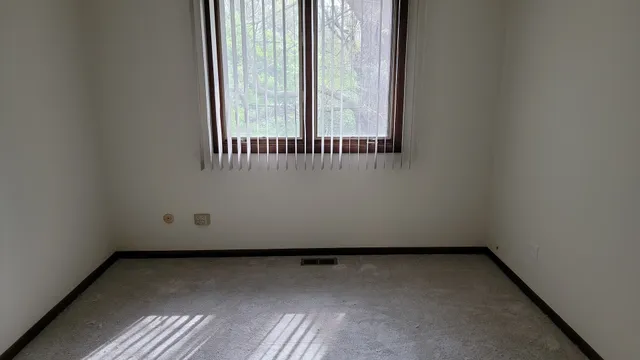 a view of a small space with wooden floor and a window