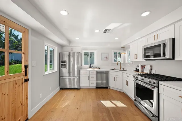 a large kitchen with stainless steel appliances granite countertop a stove and a sink