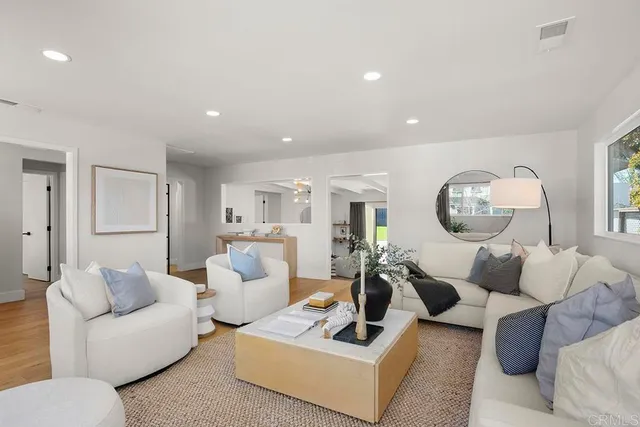 a living room with furniture a large window and a table