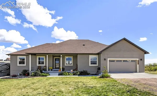 a front view of a house with yard outdoor seating and garage