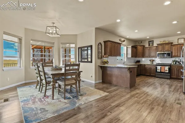 a living room with stainless steel appliances kitchen island granite countertop furniture wooden floor and a kitchen view