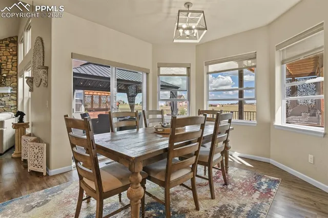 a dining room with furniture a chandelier and wooden floor