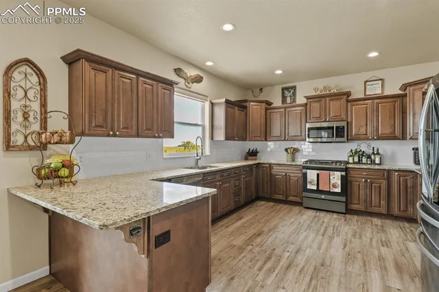 a kitchen with stainless steel appliances granite countertop a stove refrigerator and a sink