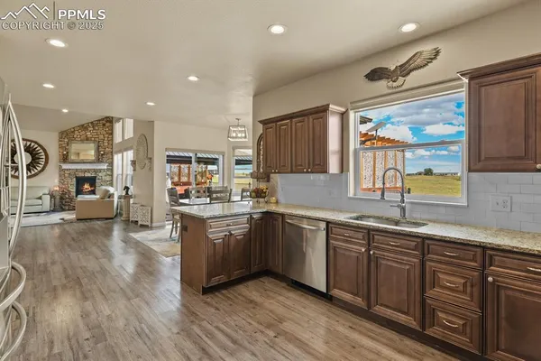 a large kitchen with stainless steel appliances granite countertop a lot of counter space and wooden floors