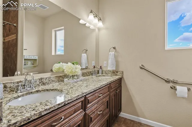 a bathroom with a granite countertop sink and a mirror