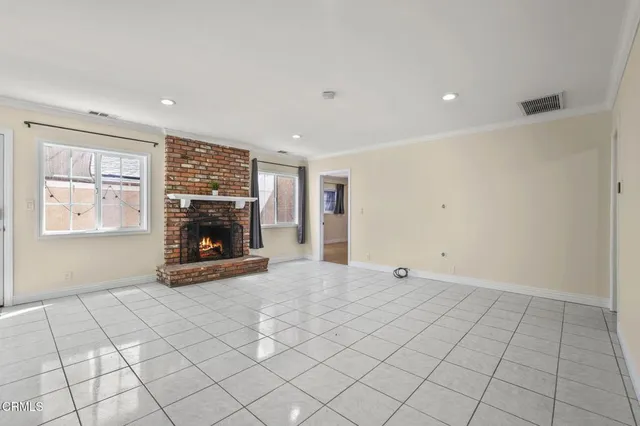 a view of empty room with fireplace and window