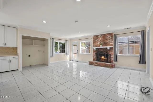 an empty room with fireplace and windows