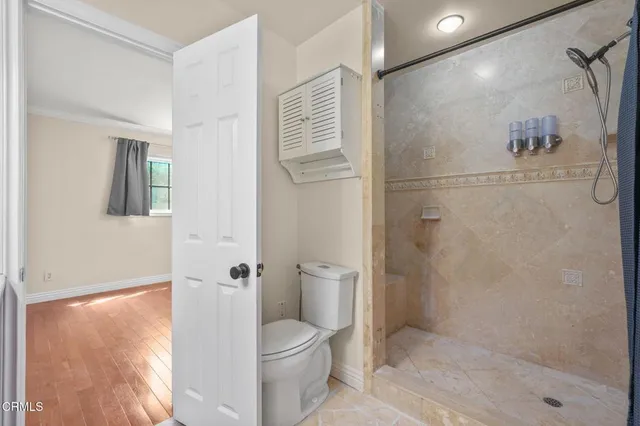 a bathroom with a granite countertop shower a toilet and a shower