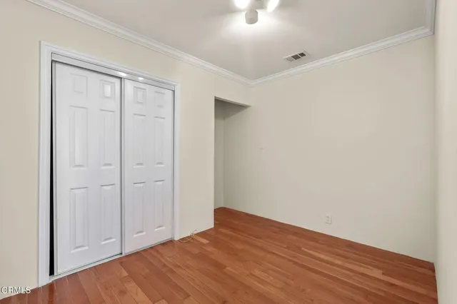 a view of empty room with wooden floor