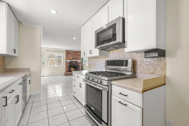 a kitchen with granite countertop a stove top oven and cabinets