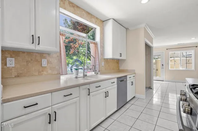 a kitchen with a sink window and cabinets