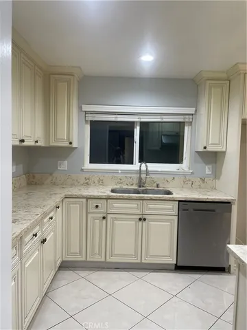 a kitchen with granite countertop white cabinets and a sink