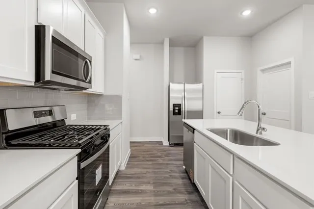 a kitchen with stainless steel appliances granite countertop a sink stove and microwave