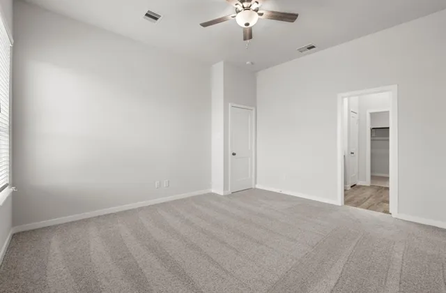 a view of an empty room with a chandelier fan