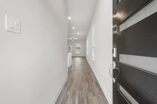 a view of a hallway with wooden floor and staircase