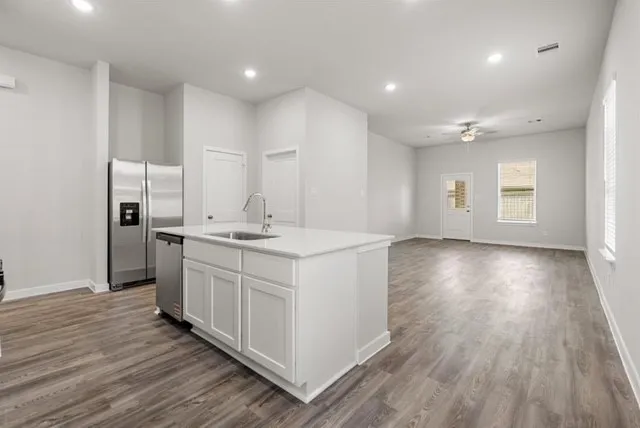 a large white kitchen with a sink and dish washer