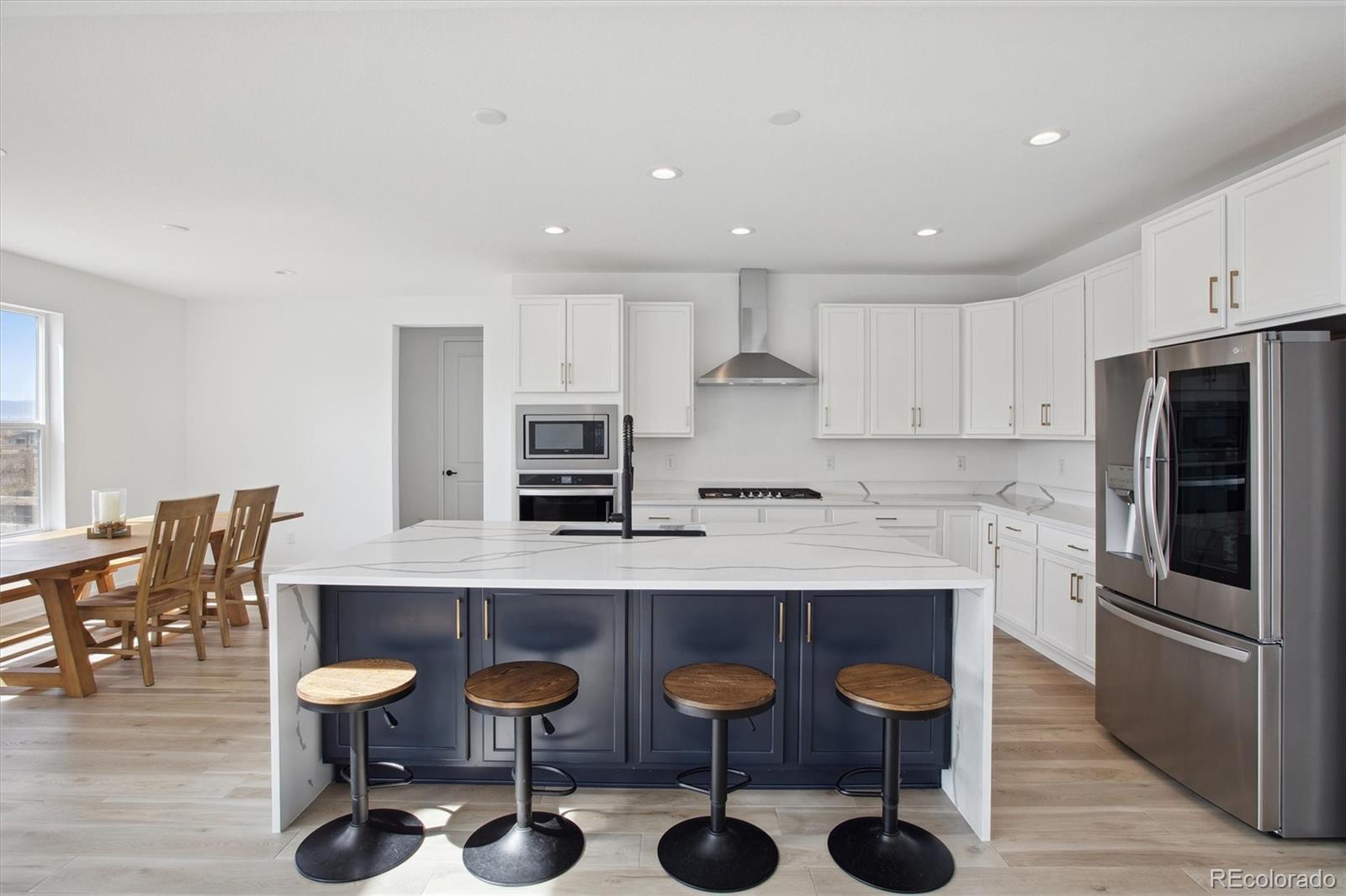 741 Simmental Loop Castle Rock, CO 80104 - Photo 12 of 50 a kitchen with stainless steel appliances granite countertop a dining table chairs refrigerator and sink