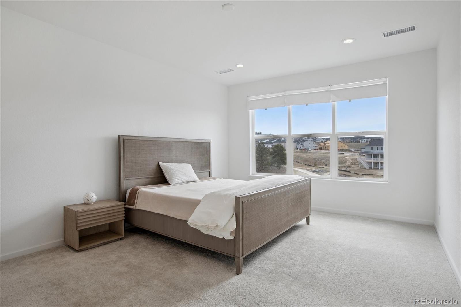 741 Simmental Loop Castle Rock, CO 80104 - Photo 22 of 50 a spacious bedroom with a bed and a large window