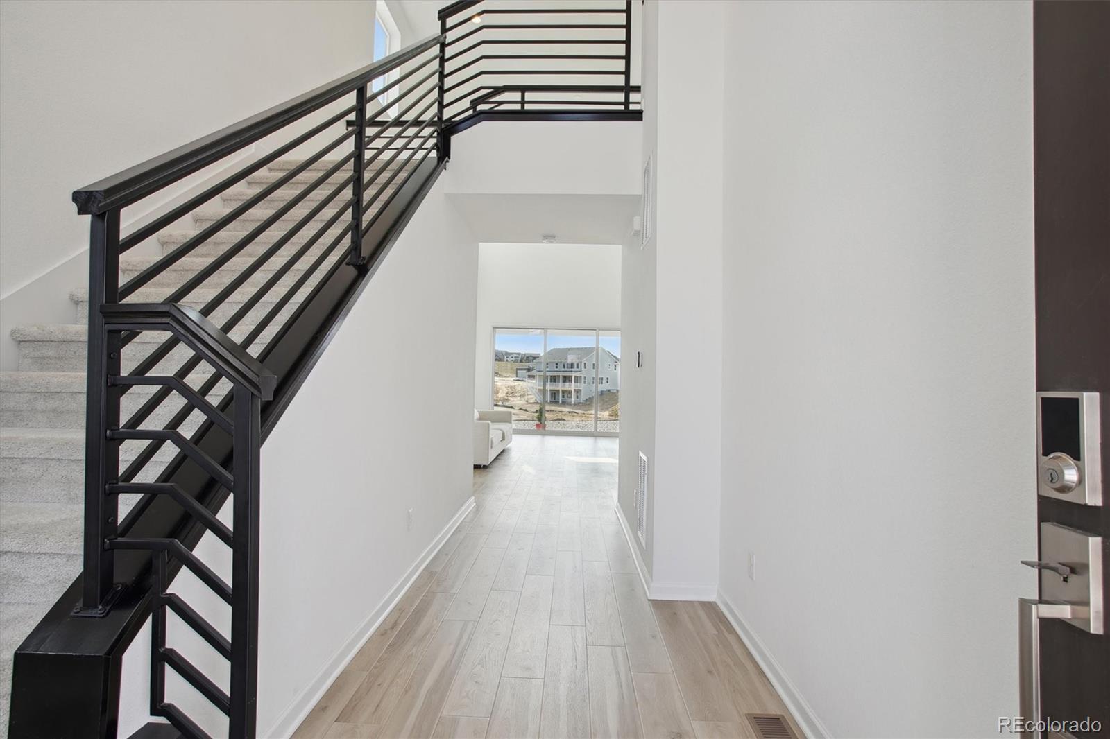 741 Simmental Loop Castle Rock, CO 80104 - Photo 5 of 50 a view of a hallway with wooden floor and staircase